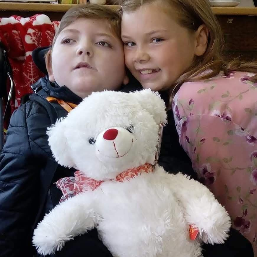 A photo of Callum (on the left) and Kelcea (on the right) with a white bear between them